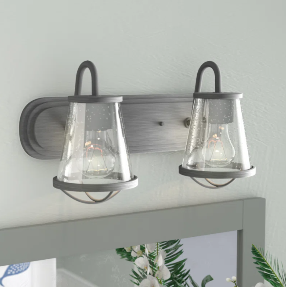 Wall-mounted light fixture with two glass shades on a neutral background