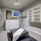 Modern bedroom with white dresser, shelves, and gray ottoman.