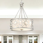 Modern kitchen with dining table and chairs, featuring a chandelier and stainless steel appliances.