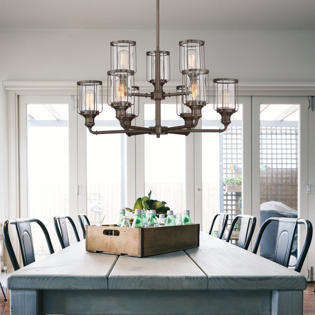 Dining room with a large wooden table and chairs, featuring a chandelier.
