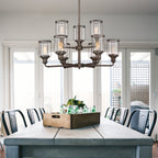 Dining room with a large wooden table and chairs, featuring a chandelier.