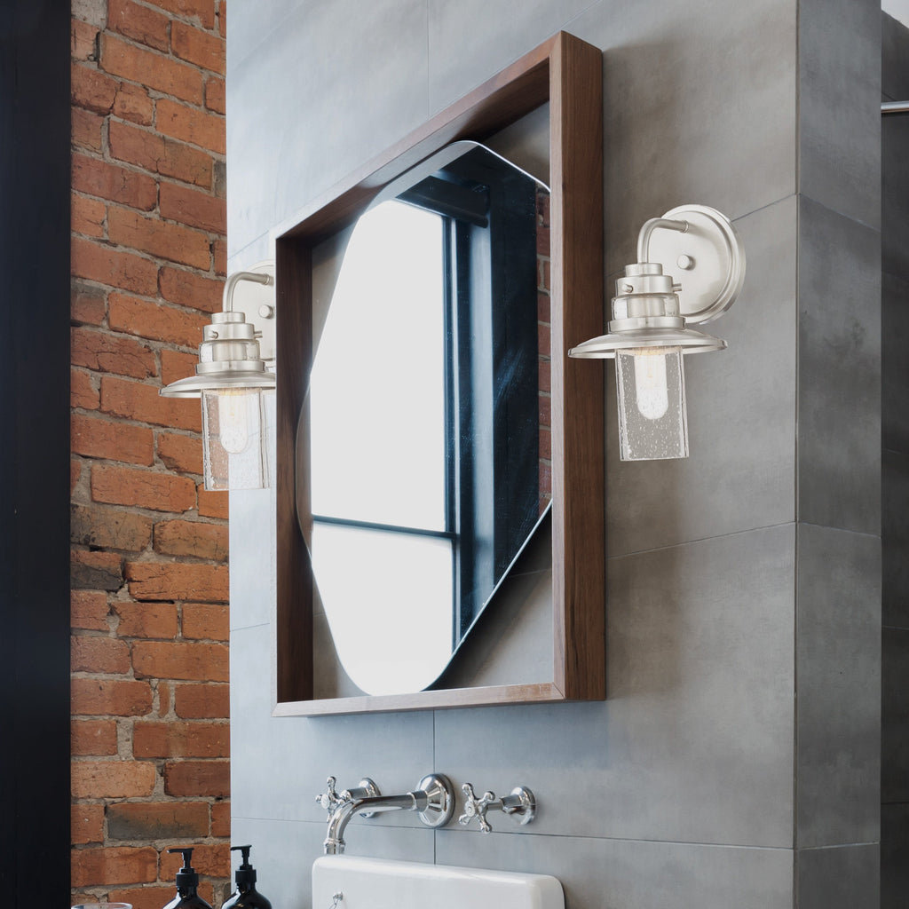 Modern bathroom with white sink, mirror, and shower area.
