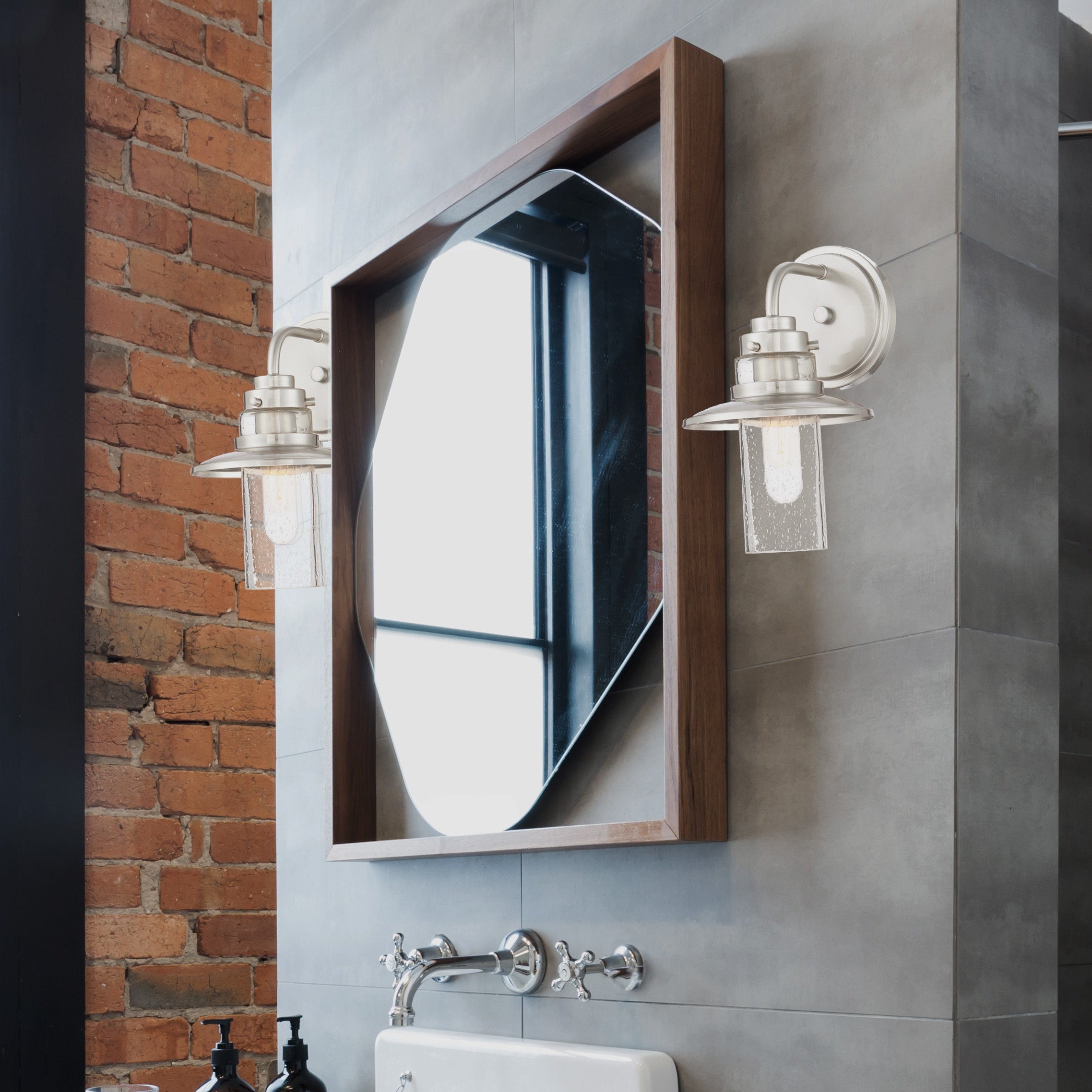 Modern bathroom with white sink, mirror, and shower area.