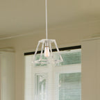 Modern kitchen with pendant light, window blinds, and decorative elements.
