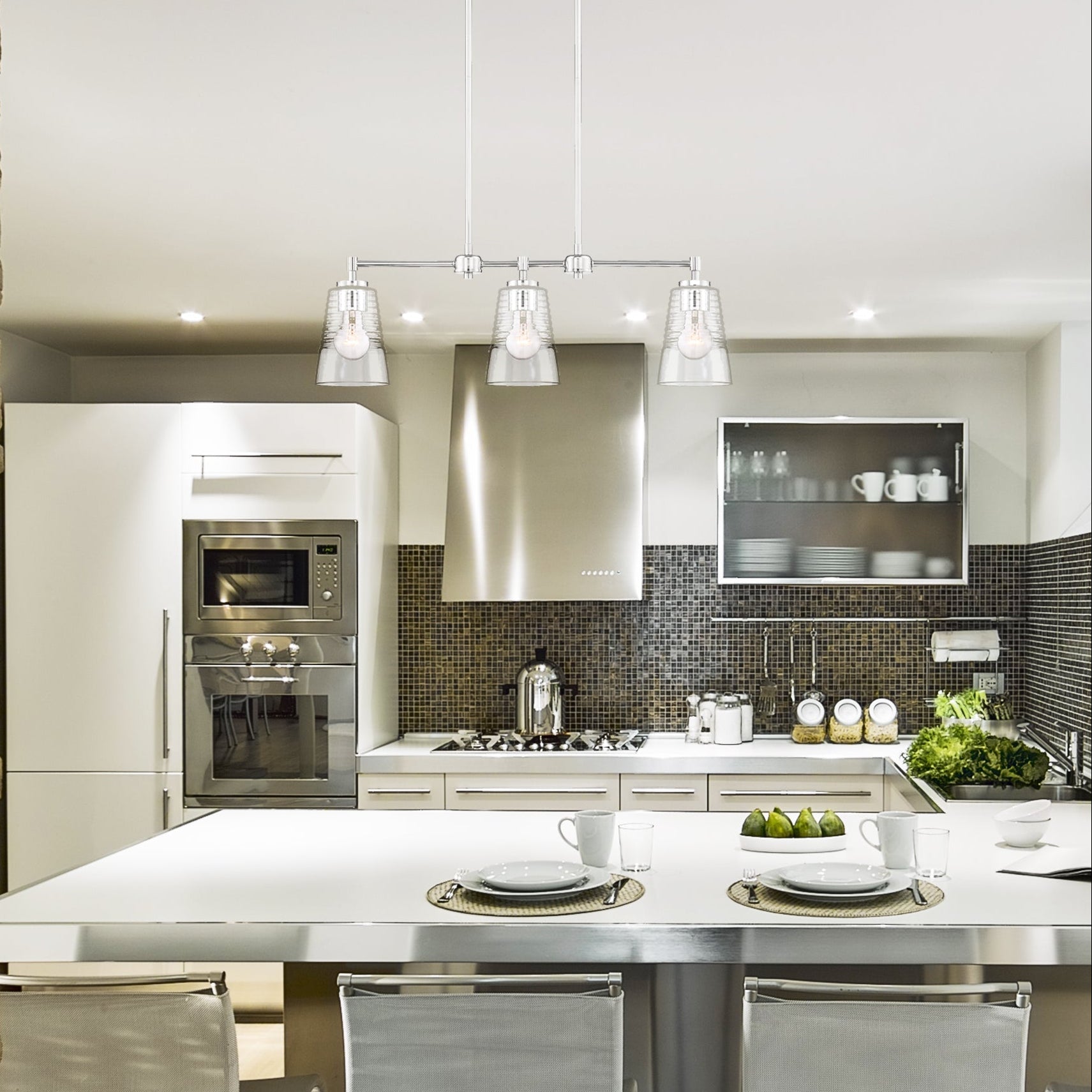 Modern kitchen with stainless steel appliances and white countertops.